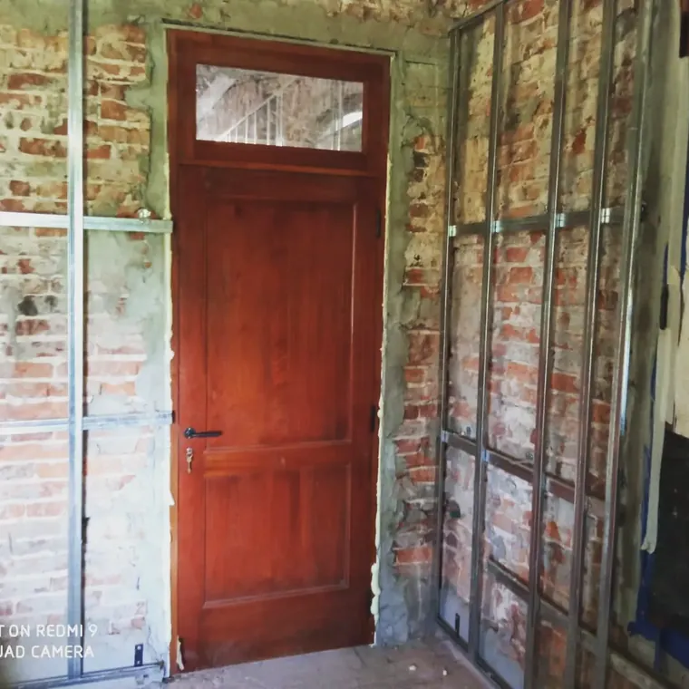 Puerta de madera con banderola colocada en una obra